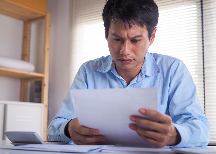 Man looking confused while looking over his retirement planning documents.